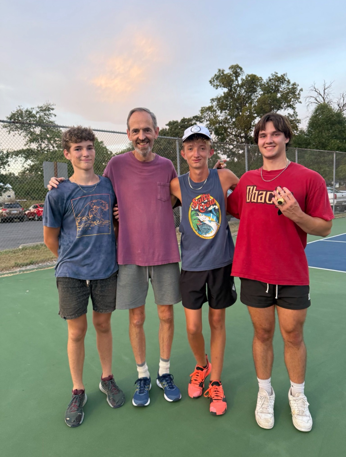 Group of players posing on the court at sunset